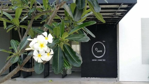 A building entrance with a black door and a sign that reads "Ozone | Khao Tao". - Ozone Khaotao (Hua Hin)