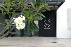 A building entrance with a black door and a sign that reads "Ozone | Khao Tao".
