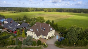 A large house with multiple rooms, a driveway, and a parking area.