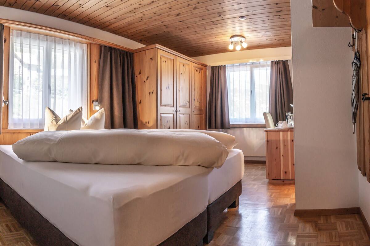Un dormitorio con una cama grande, techo de madera y un armario de madera.