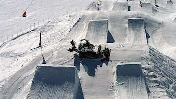 Una máquina preparadora de nieve en una pista de esquí cuidada.