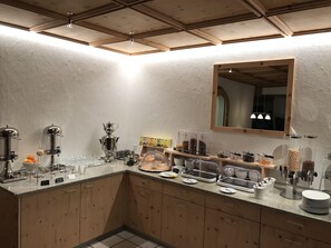 A kitchen with a wooden countertop, stainless steel appliances, and a mirror above the sink. - Hotel Panorama (Scuol)