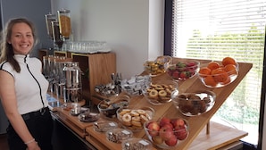 Una mesa de buffet con diversos alimentos y una estación de café.