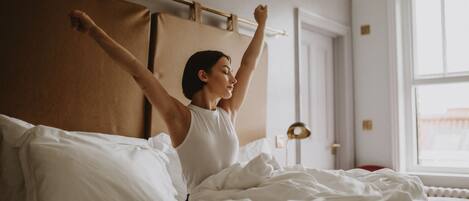 A bed with white bedding and a wooden headboard.