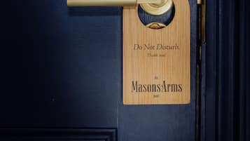 A wooden door with a brass handle and a sign that reads "Do Not Disturb. Thank you! The Masons Arms hotel."