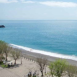 On the beach, black sand, sun-loungers, beach umbrellas
