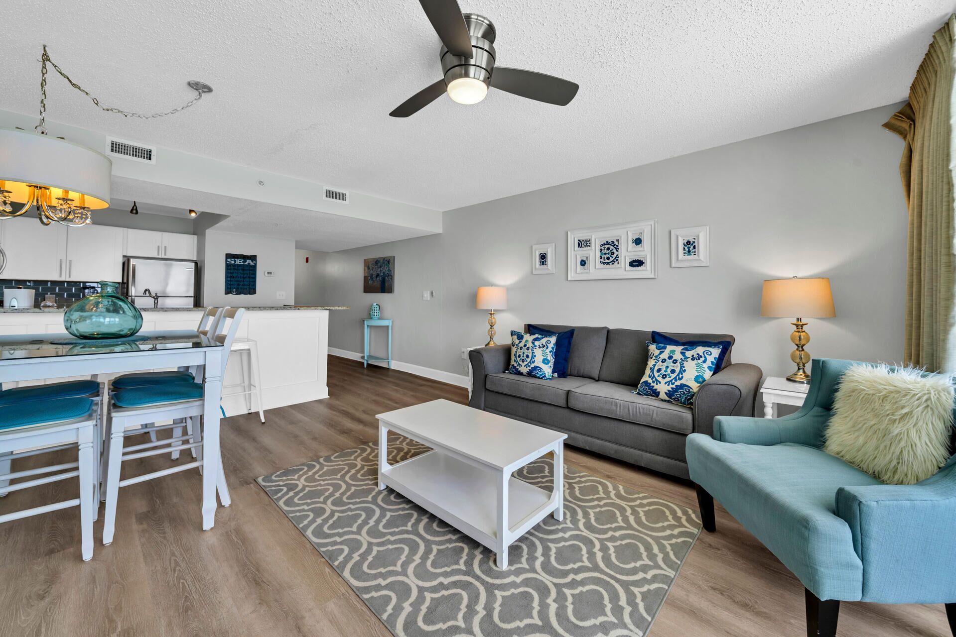 A modern living room with a sofa, coffee table, and a dining area with chairs and a table.