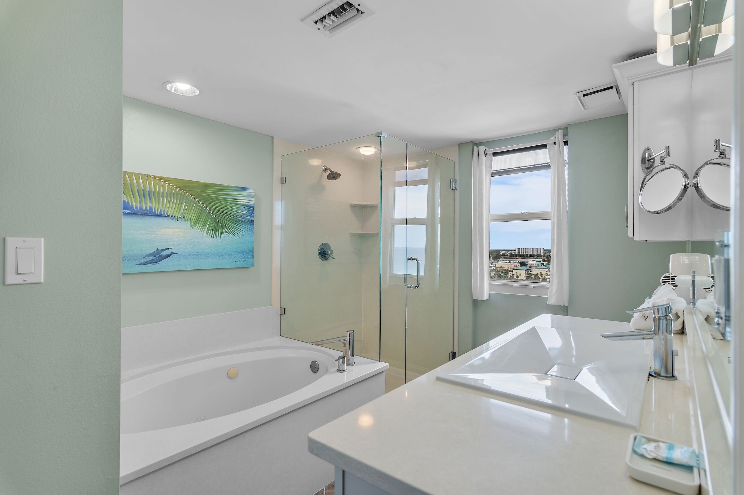 A modern bathroom with a glass-enclosed shower, a large bathtub, and a dual sink vanity.