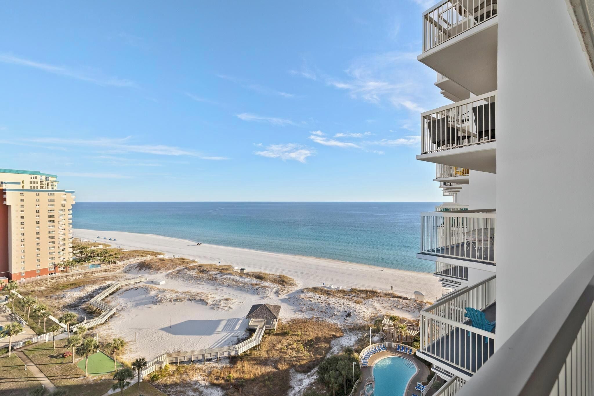 A beachfront hotel with a pool, beach access, and a view of the ocean.