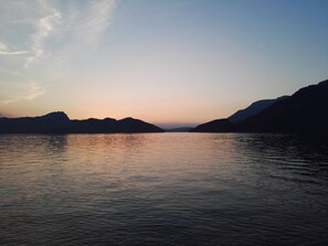 Een rustig meer met bergen op de achtergrond.