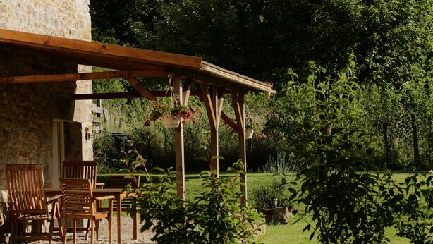 A rustic stone building with a wooden pergola and outdoor seating area. - quiet cottage, near Poligny and Arbois, vineyards, lakes, waterfalls, hiking (Villerserine)