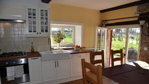 A kitchen with white cabinets, a wooden countertop, and a window with a view of a green landscape. - quiet cottage, near Poligny and Arbois, vineyards, lakes, waterfalls, hiking (Villerserine)