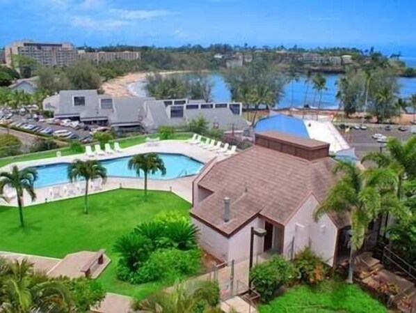 Ein Resort mit Pool, Palmen und Blick auf den Ozean.