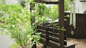 Eine Holz-Pergola mit einer rankenden Pflanze.
