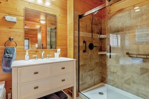 Een bad/douchecombinatie, een bubbelbad, een haardroger, handdoeken