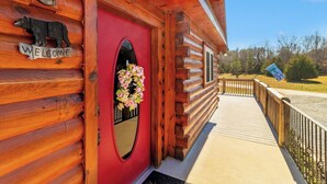 A wooden cabin with a red door, a welcome sign, and a flower arrangement. -  7 person new HOT TUB  at Stunning Log Cabin 4 bed 4 full bath  5 min  to TI (Rutherfordton)