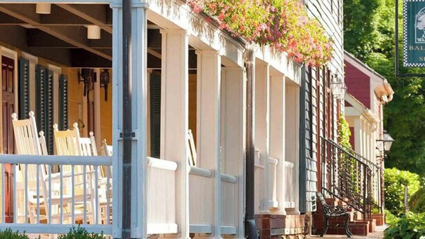 A row of white-framed windows with a balcony, a bench, and a signboard. - Nestled Among Majestic Trees, Hilltop Hideaway is a Woodland Sanctuary (Amissville)
