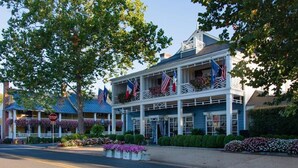 A two-story building with balconies, flags, and a stop sign in the foreground. - Nestled Among Majestic Trees, Hilltop Hideaway is a Woodland Sanctuary (Amissville)