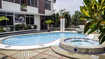 Una piscina al aire libre, sillones reclinables de piscina