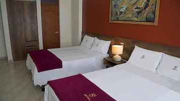 A hotel room with two beds, a wooden wardrobe, a painting on the wall, and a nightstand with a lamp.