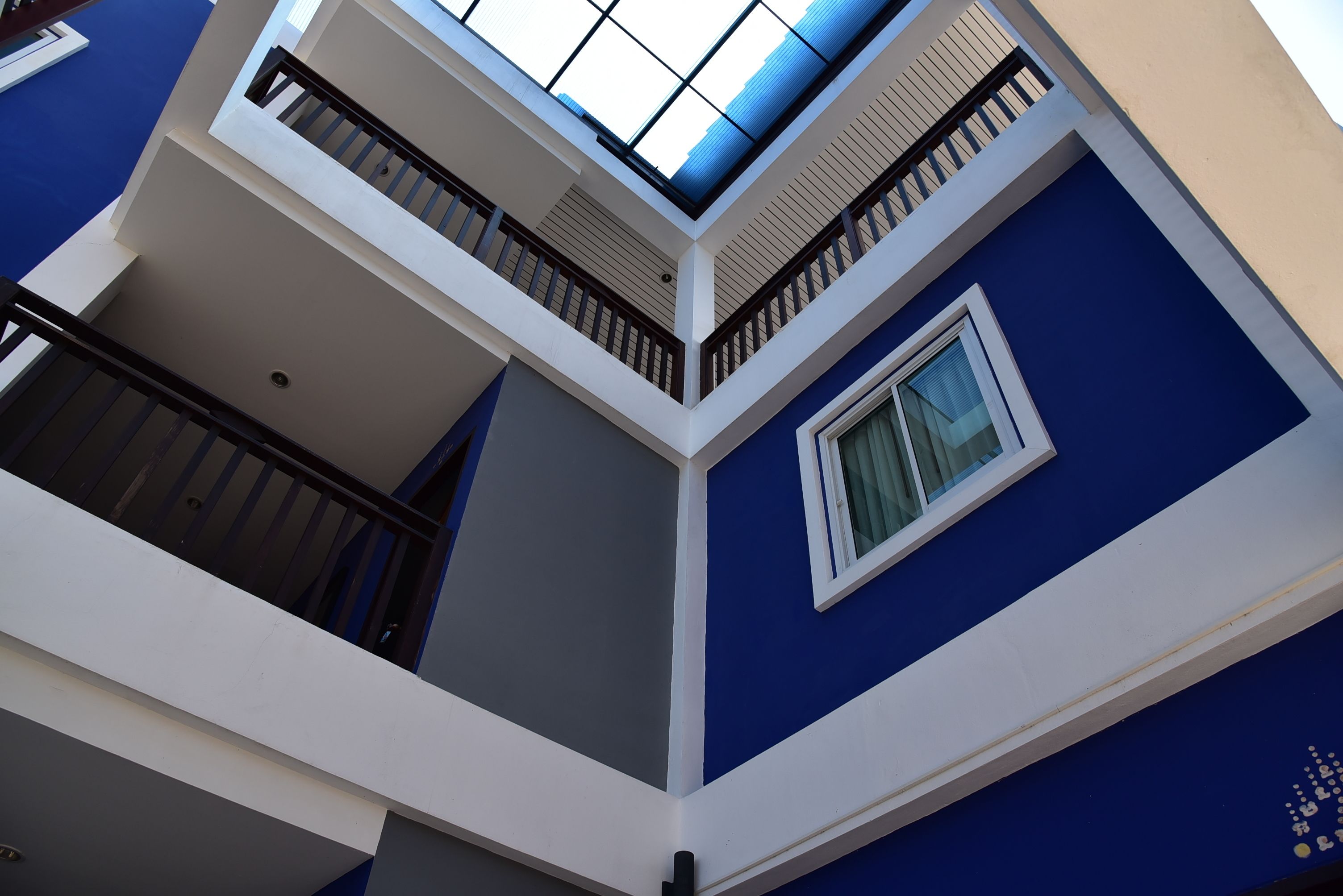 A multi-level building with a blue exterior, a skylight on the upper floor, and a window on the lower floor.