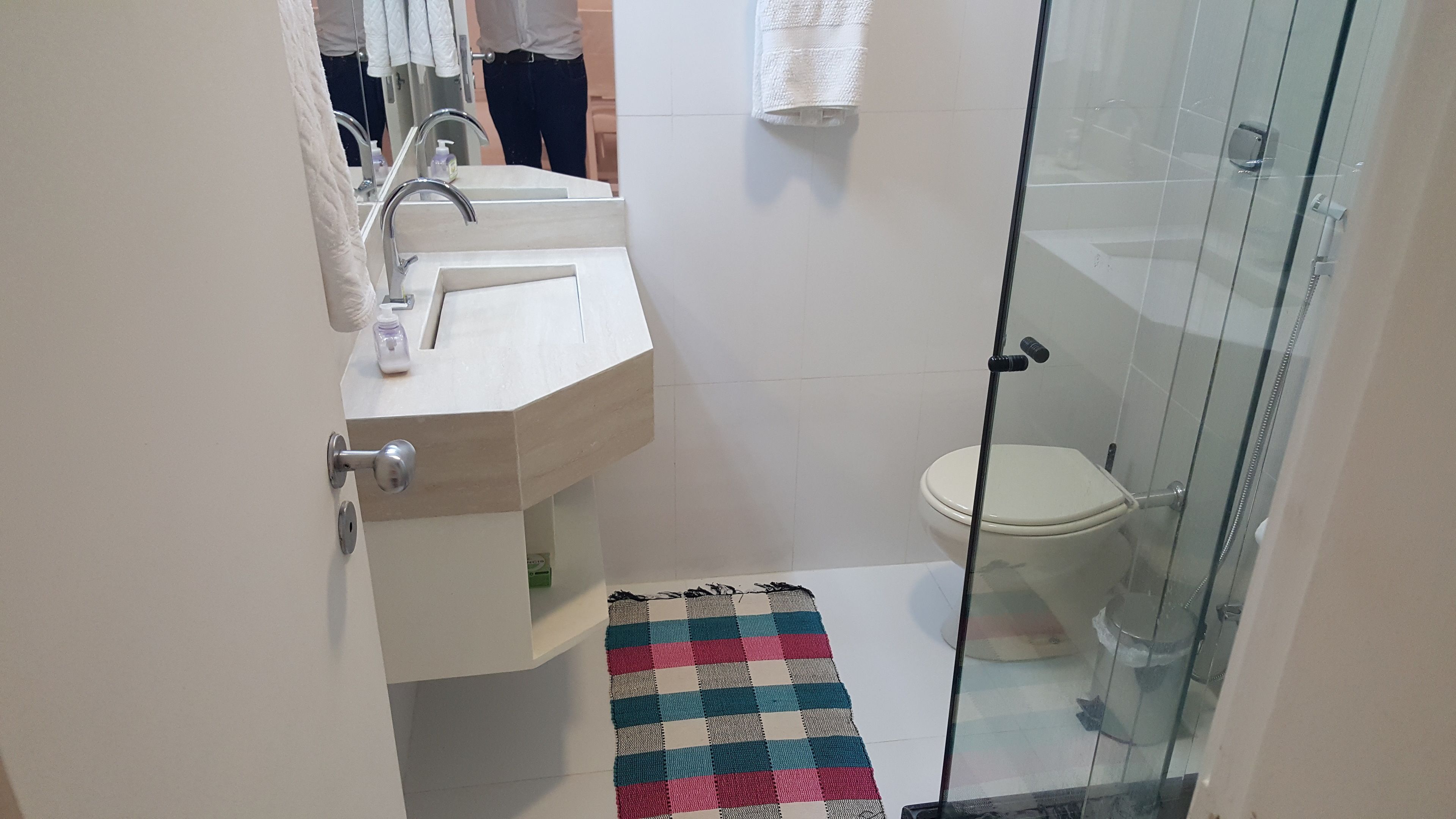 Un baño con lavamanos, espejo e inodoro.