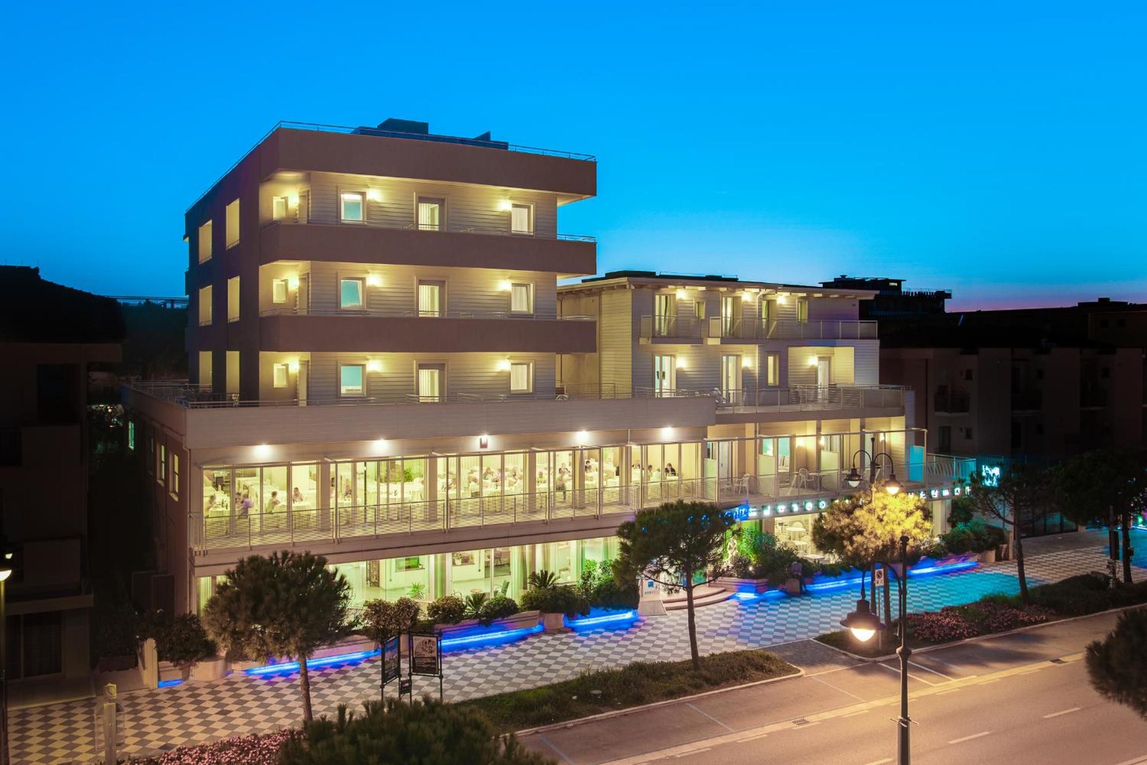 A multi-story hotel with a checkered outdoor area and a pool.