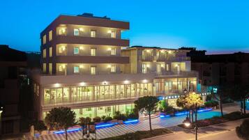A multi-story hotel with a checkered outdoor area and a pool.