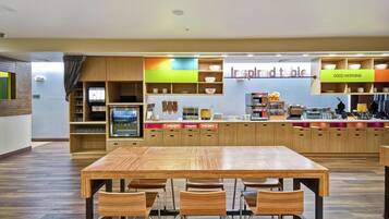 A restaurant with a wooden table and chairs, a counter with a menu, and a sign that reads 'inspired table'.