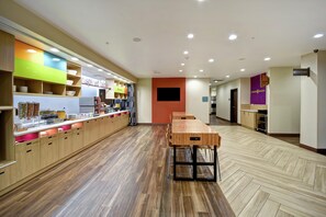 Un restaurant moderne doté d’un long comptoir, d’un plancher en bois et d’une variété de bols et d’ustensiles exposés.