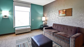 A modern living room with a sofa, a side table, a lamp, and a radiator.