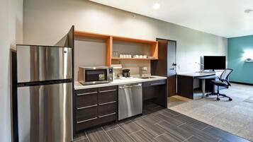 A compact kitchenette with a refrigerator, microwave, and a small countertop.