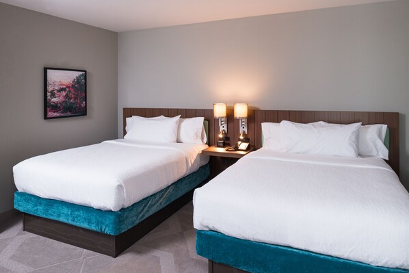 A hotel room with two beds, a nightstand with lamps, and a framed picture on the wall. - Hilton Garden Inn Little Rock Downtown (Little Rock)