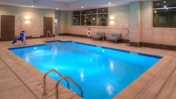 Una piscina techada, sillones reclinables de piscina