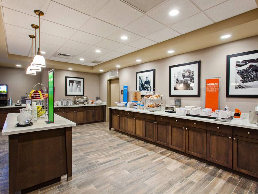 Una cocina de hotel amplia con una encimera larga, diferentes alimentos y una estación de café.