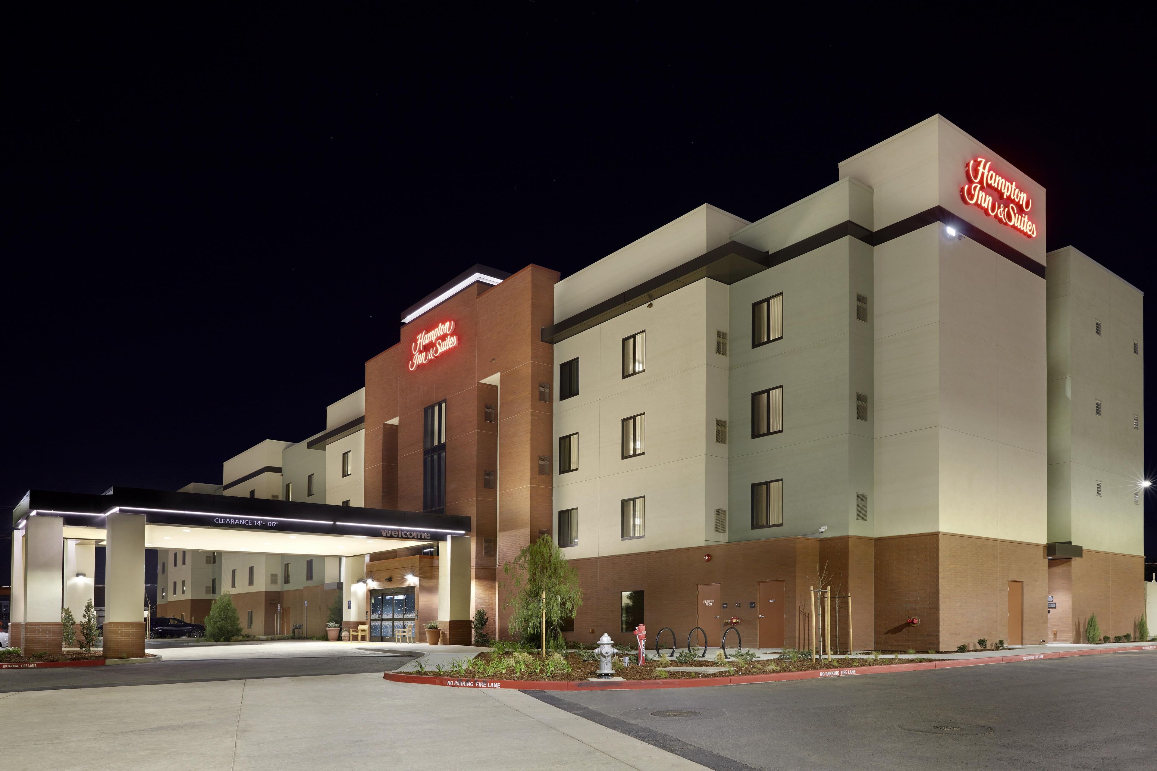 Un hotel Hampton Inn & Suites con entrada despejada, zona de estacionamiento e hidrante.