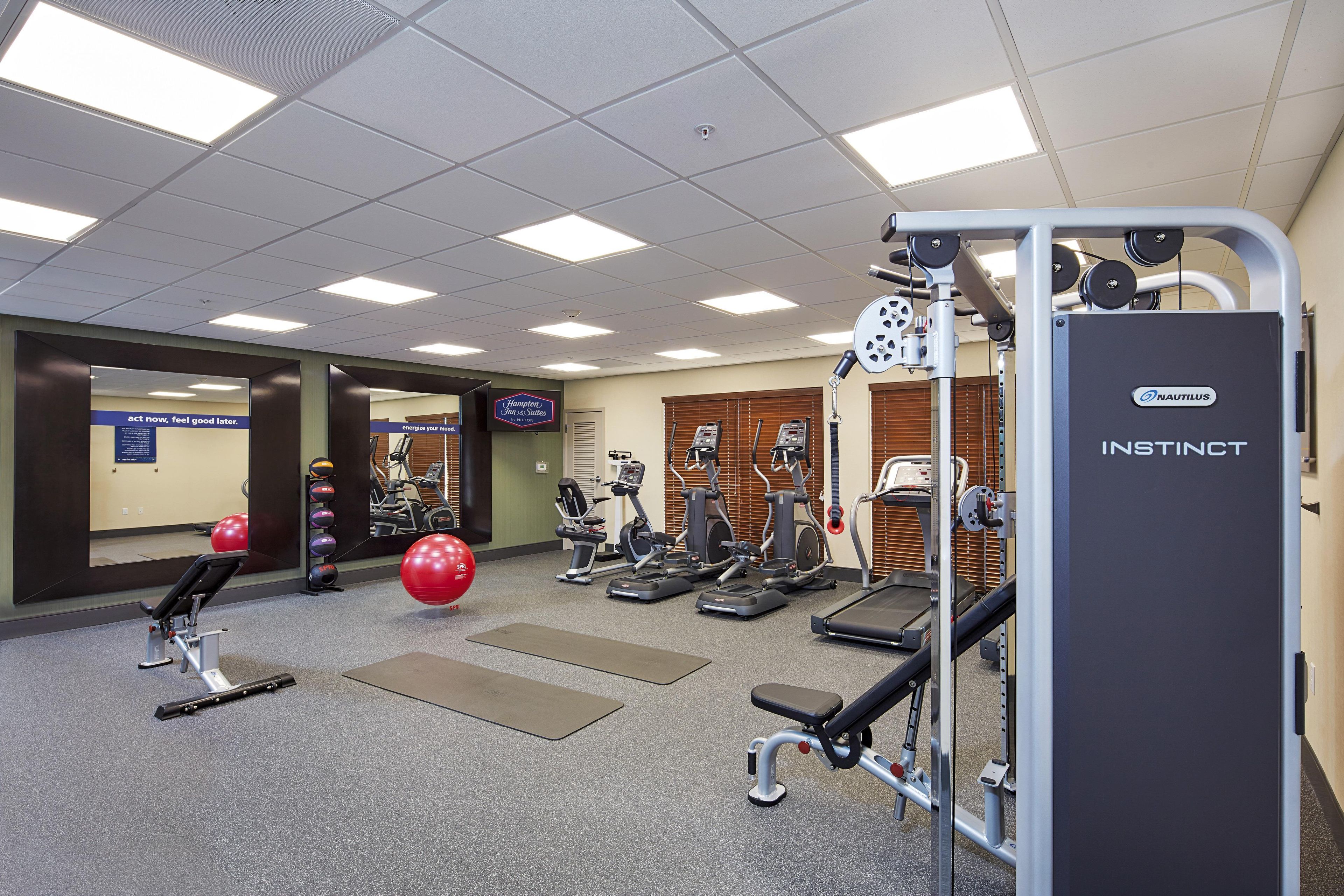 A gym with treadmills, elliptical machines, and free weights.