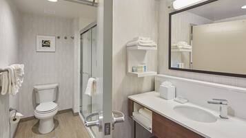 A modern bathroom with a toilet, sink, and shower area.