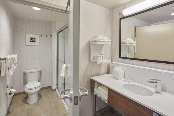 Un baño moderno con inodoro, lavamanos y zona de ducha.