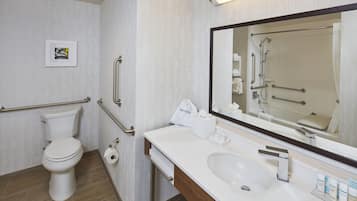 Een hotelbadkamer met toilet, bidet, wastafel en een grote spiegel.