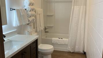 Habitación Deluxe, varias camas, refrigerador y microondas | Baño | Tina con regadera y toallas