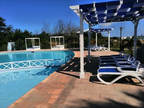 Utomhuspool, parasoller och solstolar