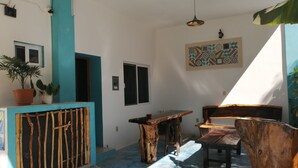 A room with a blue and white color scheme, a wooden table and chairs, a potted plant, and a wall-mounted light fixture. - Blue Coconut Cancun Hotel (Cancun)