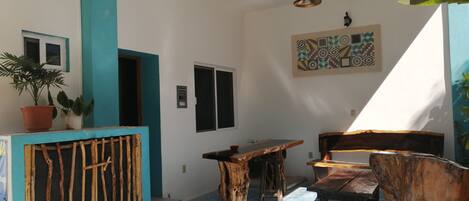 A room with a blue and white color scheme, a wooden table and chairs, a potted plant, and a wall-mounted light fixture.