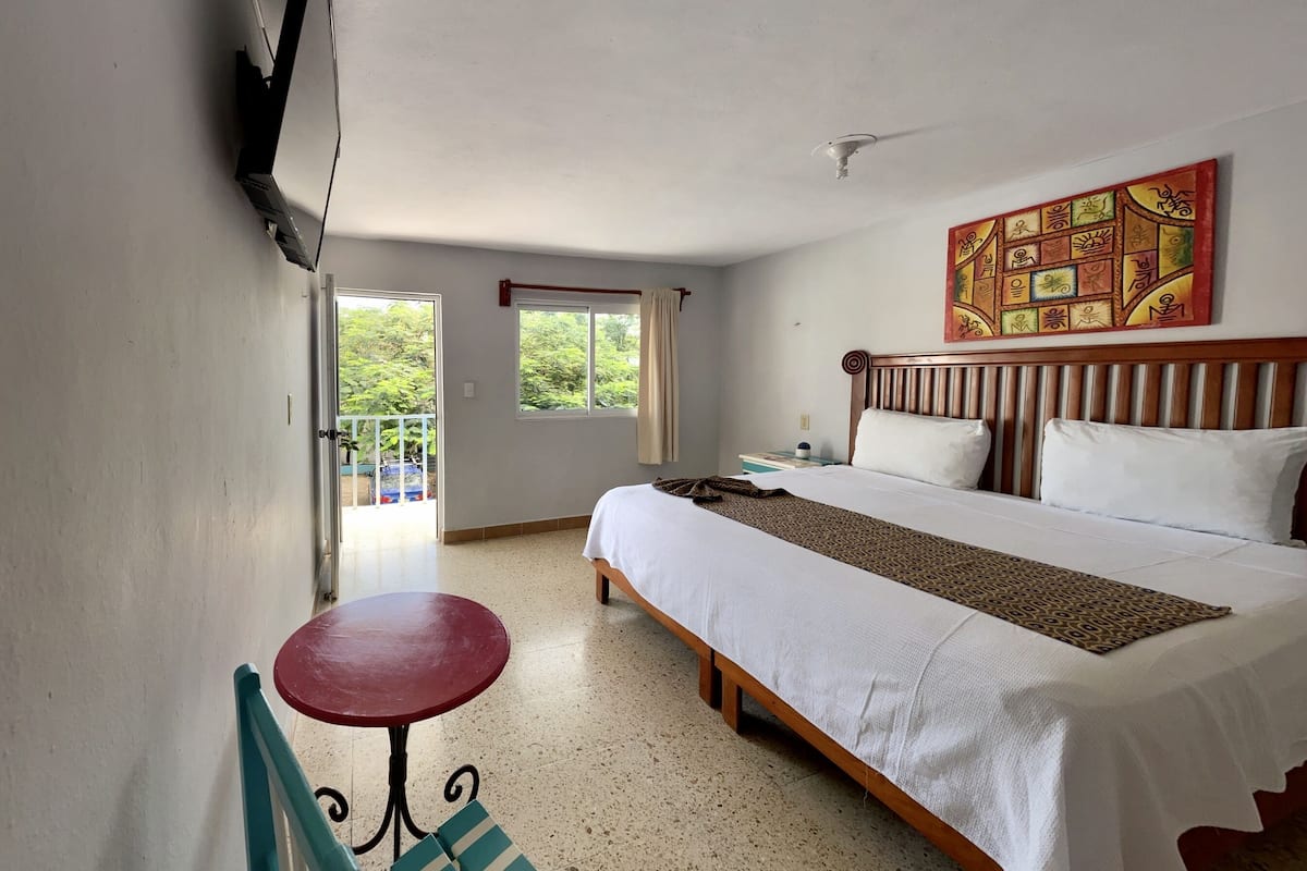 Une chambre d’hôtel avec un lit, une table et une chaise.