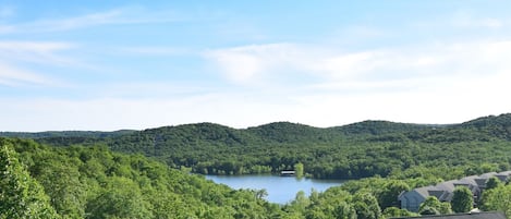 A residential area with houses, a lake, and forested hills.