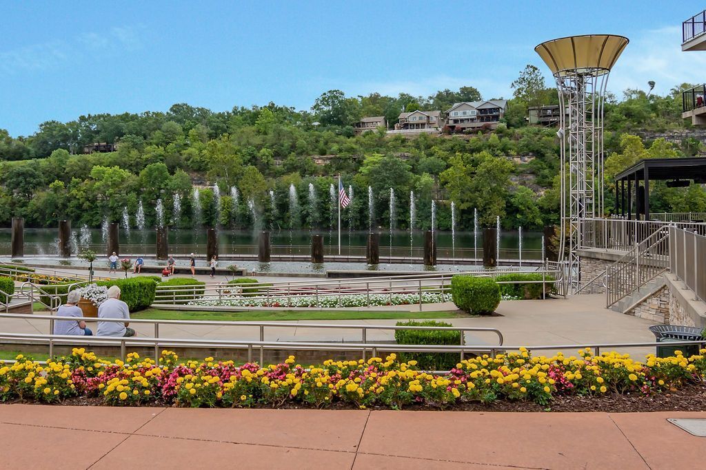 A landscaped area with a fountain, a flag, and a gazebo.