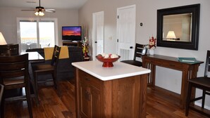 Un amplio salón con una mesa de comedor, sillas, una isla de cocina y un televisor.