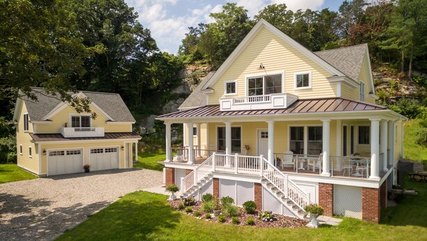 A two-story house with a front porch, a garage, and a landscaped yard.