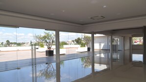 Interior espaçoso e moderno, com grandes janelas que proporcionam vista para a cidade.
